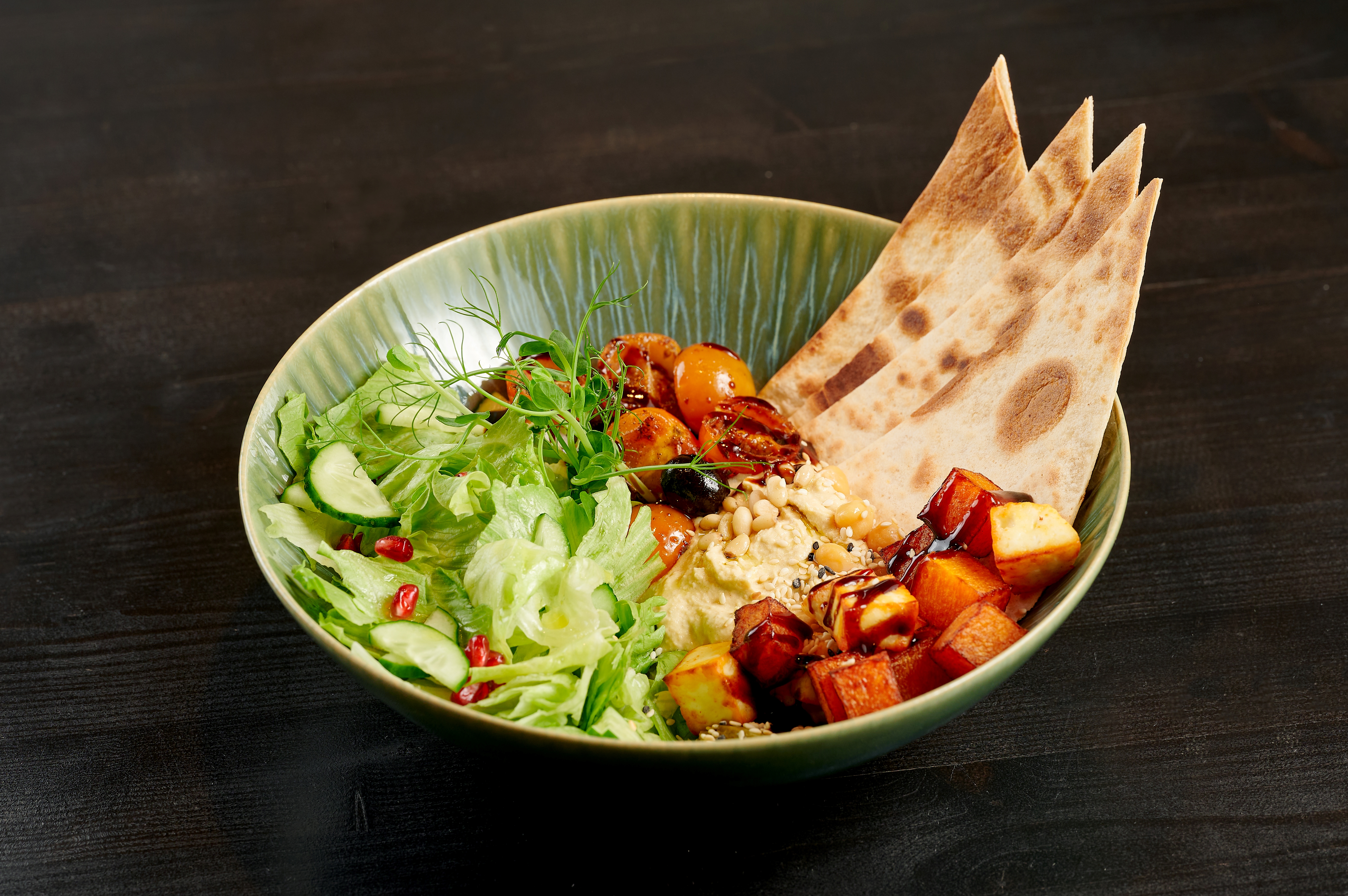 Chickpea hummus bowl with roasted tofu, tomatoes, olives and tortilla